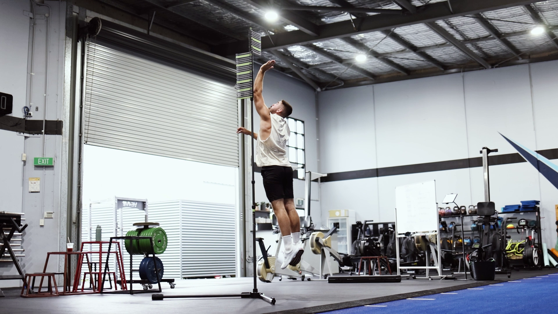 A vertical jump device being setup and used edited ina amontage style. An athletes jumps and uses his hand to hit vanes on the product that measure the height he reached while jumping.
